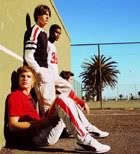Teenage guys sitting by running track sideview 