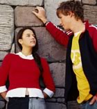 Teens talking by stone wall 