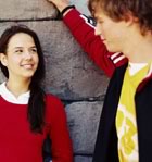 Teens talking by stone wall 