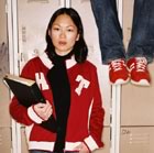 Teen standing by locker, legs dangling beside