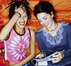 Teenage girls laughing and listening to cds 
