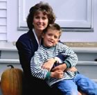 Mother & son sitting on steps with pumpkin