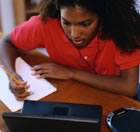 Teenage girl with laptop & paper 