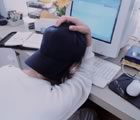 Student at computer with baseball cap