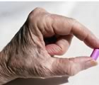 Older woman's hand with pill