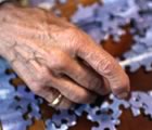 Older woman's hand with jigsaw puzzle