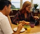 Couple having breakfast with laptop