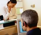Man wearing headset with woman waiting at desk