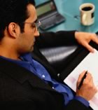 Man making notes with laptop and coffee