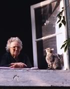 Older woman with cat in window