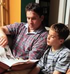 Father with young son reading newspaper