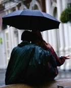 Standing in the rain with umbrella
